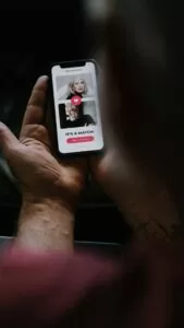 Lonely single men- man holding phone looking at online dating profile