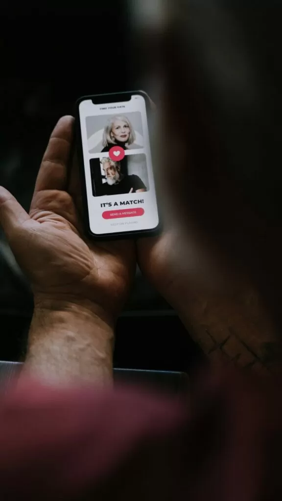 Lonely single men- man holding phone looking at online dating profile